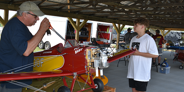 Larry Folk (L), assisted by his grandson, Nicholas Kelty (R), assembling the 1/3-scale Fly Baby.