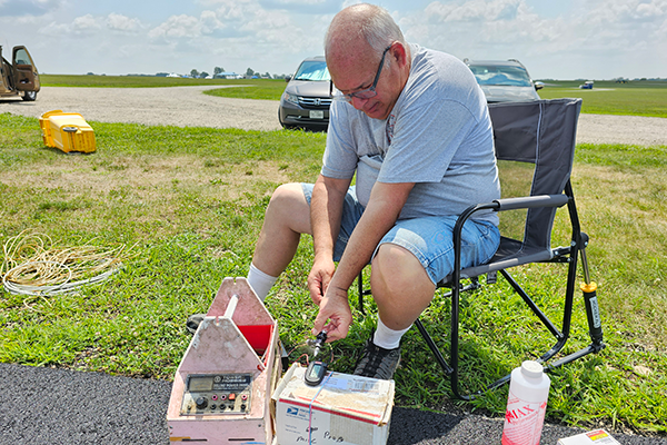 Mike Greb, of TX, shows brave form as he holds his Cox .049 with his bare fingers in front of his tachometer.