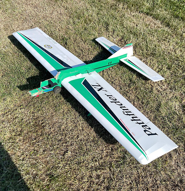 Remote-controlled airplane on grass.