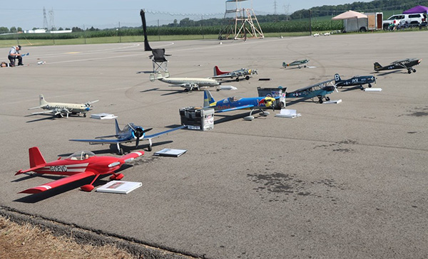 Model airplanes on a large open tarmac, spaced in two rows.