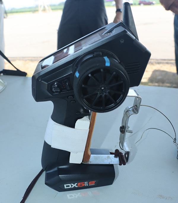 Remote control on a table, with a wheel and antenna.