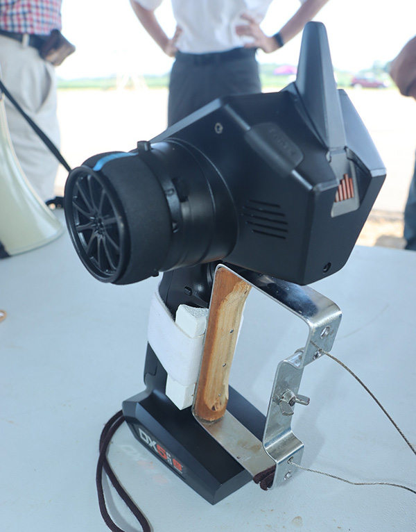 Device with a large lens on a metal stand on a table outdoors.