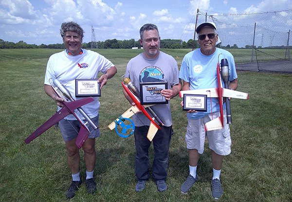 Three Men holding a model CL Speed airplane
