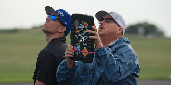 Two attendees looking to the sky during competition.