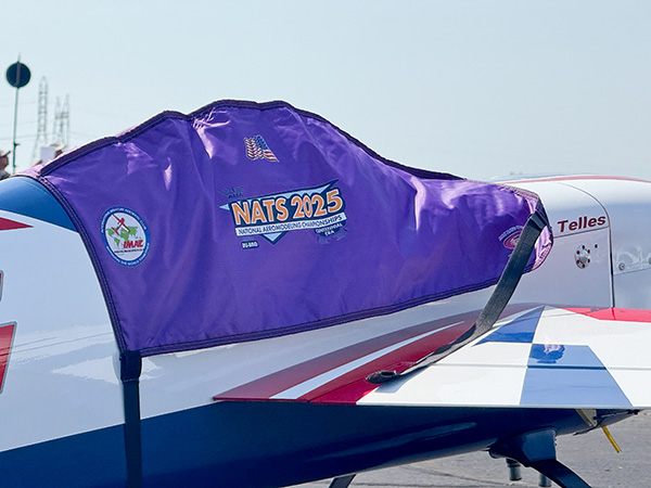 Purple cover on airplane wing with &quot;NATS 2023&quot; logo.