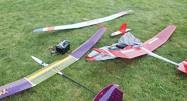 Model gliders and equipment on grass.