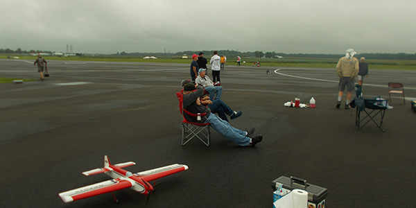 Pilots waiting their turn at the beginning of the contest. You can see the cloudy skies and wet ground that started the day.