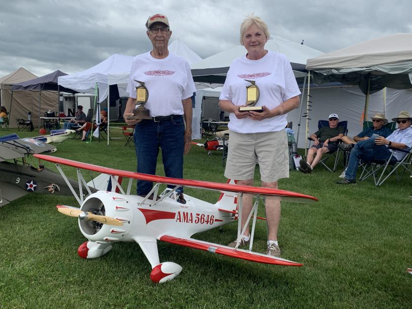 Ralph and Martha White holding Ralph’s trophies with his Waco in the foreground