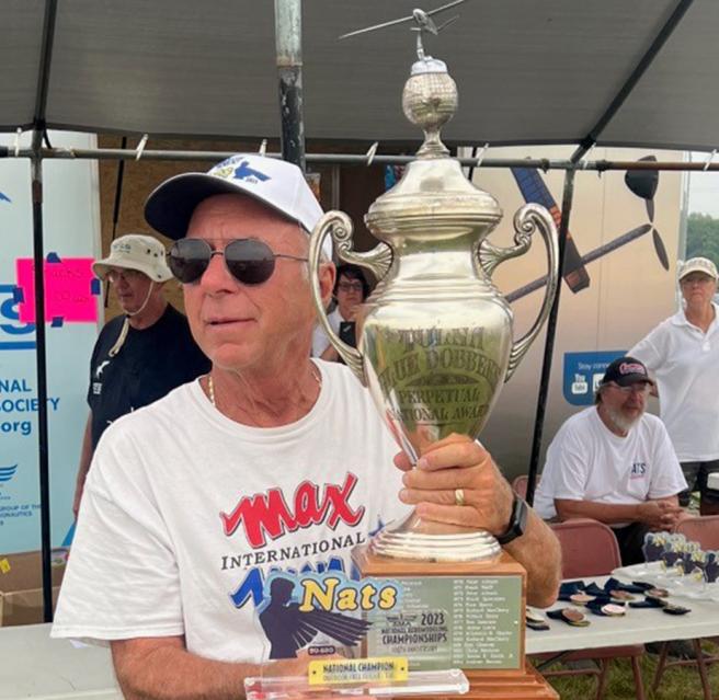 Brian Van Nest lifts the historic Tulsa Glue Dobbers perpetual trophy for National Champion in F1A glider.