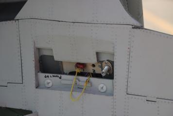 – With the access hatch removed on the P-39 you can see the wing attach bolts, electric arming plug, and the fill jack for the a