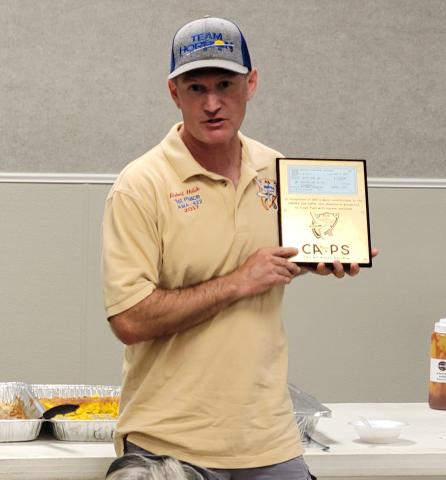 Robert Holik accepts the plaque to commemorate a donation for Crash Fund, Inc., on behalf of Annie Torres.