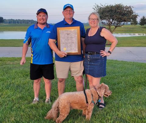 Dan Kane holding his AMA Hall-of-Fame induction plaque with son Jack, wife Catherine and Finnegin.
