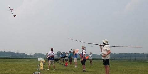 Dave Resinger launches into a steamy day flight. Josh Glaab waits patiently with his sailplane lower to the ground, and Dave Bradley Jr. shoulders his sailplane.