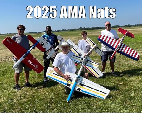 Five people holding model airplanes on a grassy field.