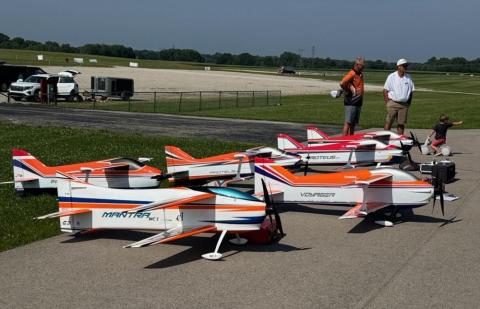 Large model airplanes on a runway, with people in the background.