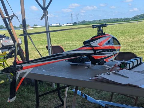 Large remote-controlled helicopter on table outdoors.