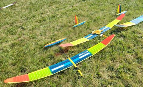 Colorful model sailplanes on grass.