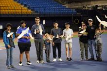 Group with model airplanes in a stadium setting.