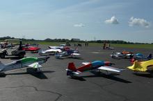 Model airplanes on an airfield, people gather in the background.