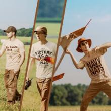 Three men outdoors in vintage aviation-themed outfits.
